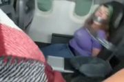 飛機在天上飛著，女乘客要開艙門，被五花大綁綁在座椅上