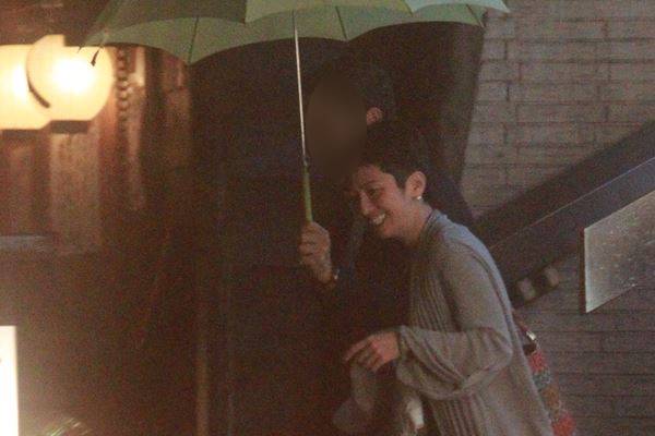 蓮舫笑容滿面地和男秘書同撐一把傘